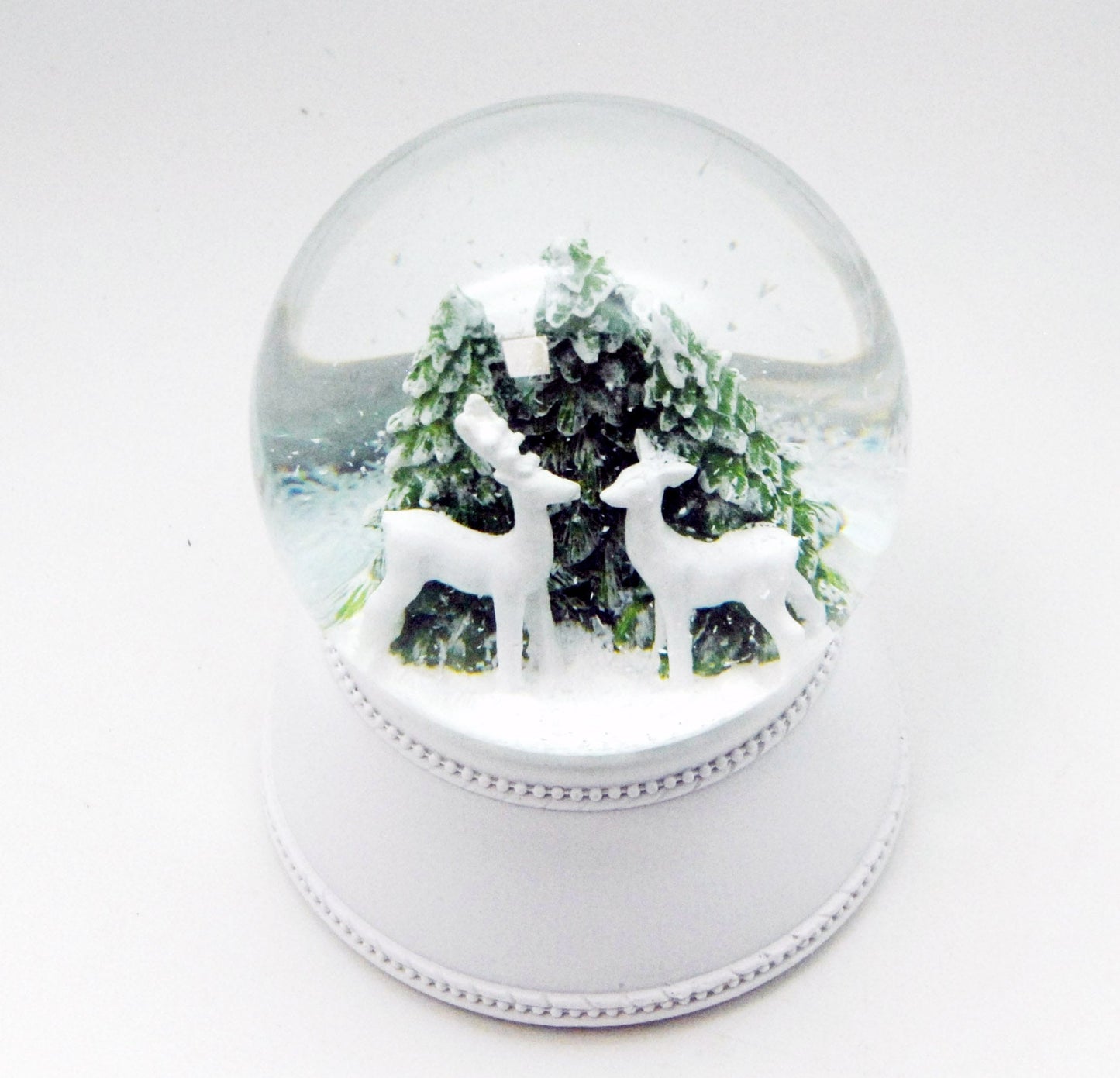 Nostalgische Schneekugel 2 Rehe vor Tannenbäumen auf Sockel weiß Nostalgie 100 mm Durchmesser mit Spieluhr - Schneekugelhaus