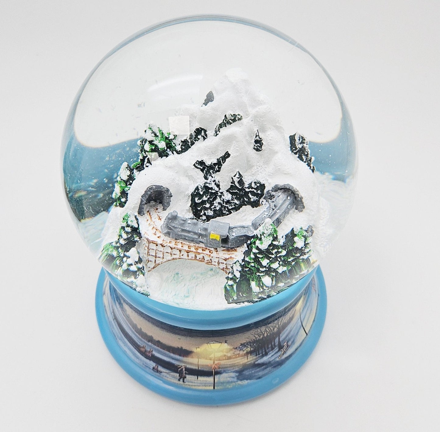Nostalgische Schneekugel Berg mit Brücke Winterlandschaft blauer Rand 100 mm Durchmesser mit Spieluhr - Schneekugelhaus