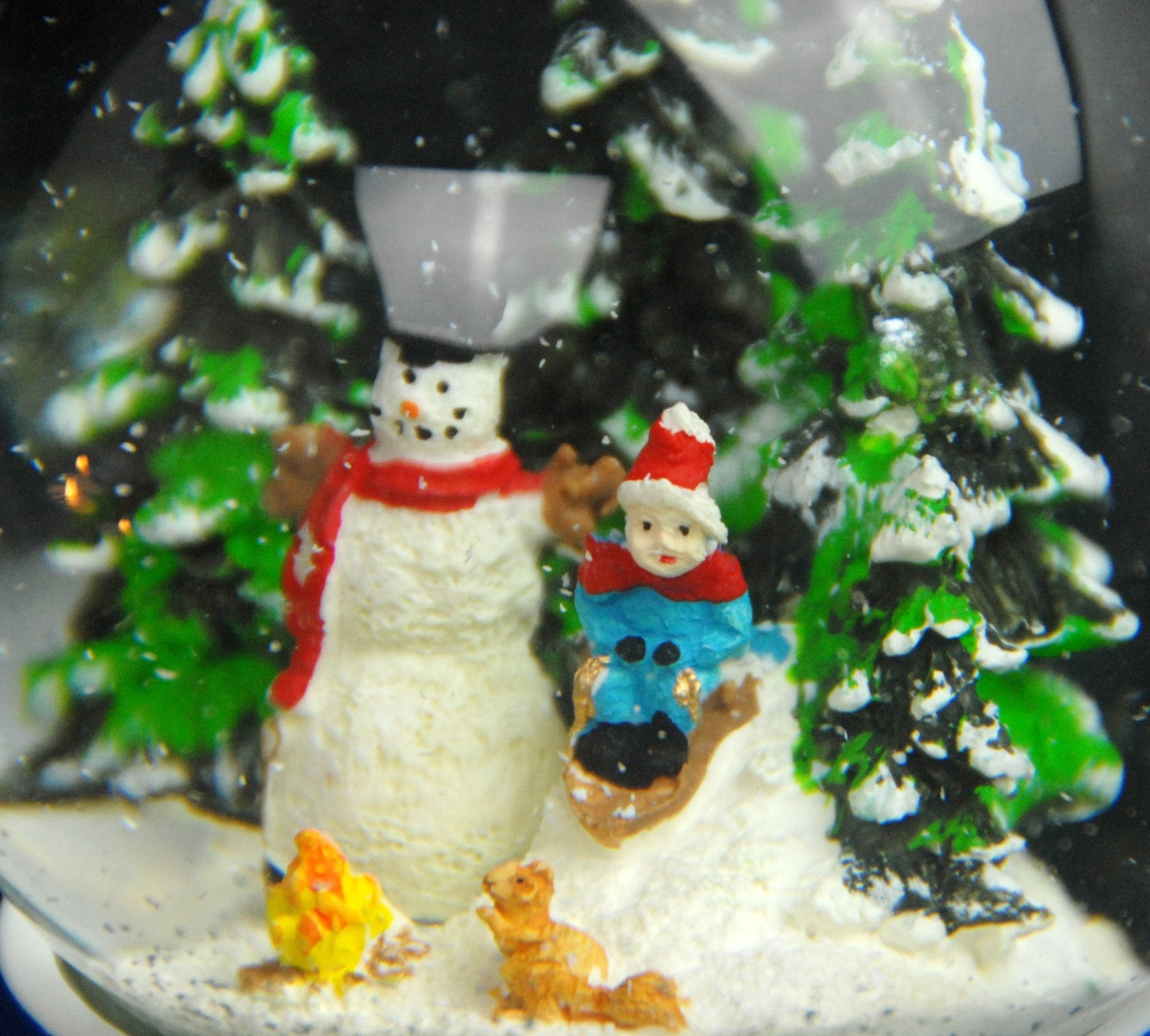 Schneekugel Schneemann steht im Winterwald mit Kind auf Schlitten auf Sockel Winterlandschaft Eisläufer blau mit Spieluhr - Schneekugelhaus