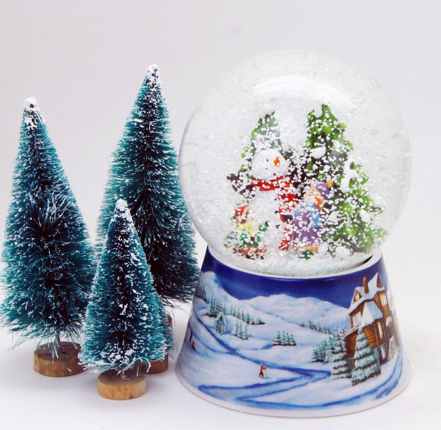 Schneekugel Schneemann zwei Kinder auf Sockel Winterlandschaft mittelblau mit Spieluhr 10 cm Durchmesser - Schneekugelhaus
