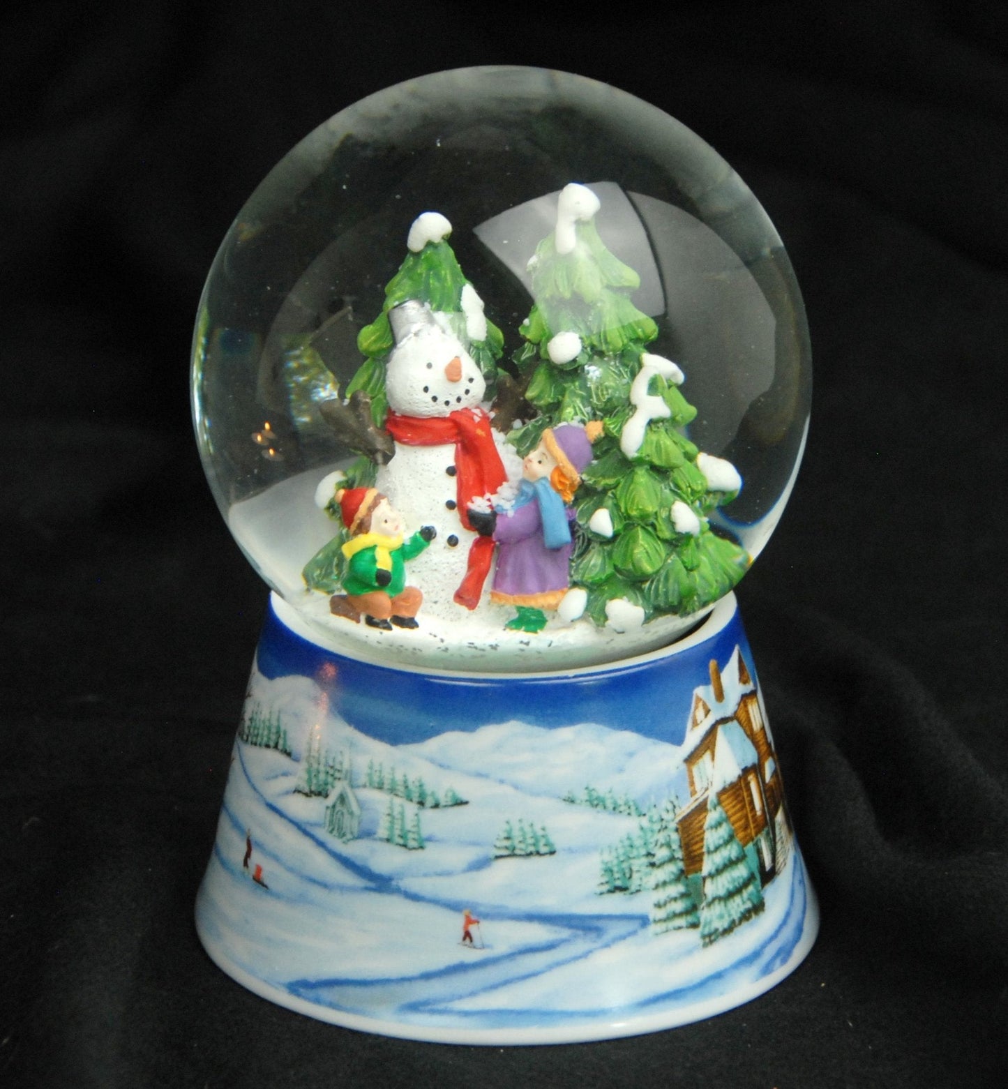 Schneekugel Schneemann zwei Kinder auf Sockel Winterlandschaft mittelblau mit Spieluhr 10 cm Durchmesser - Schneekugelhaus