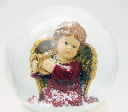 Edle Schneekugel Engel rot/gold mit Harfe auf weißem Porzellansockel 100 mm Durchmesser mit Spieluhr - Schneekugelhaus