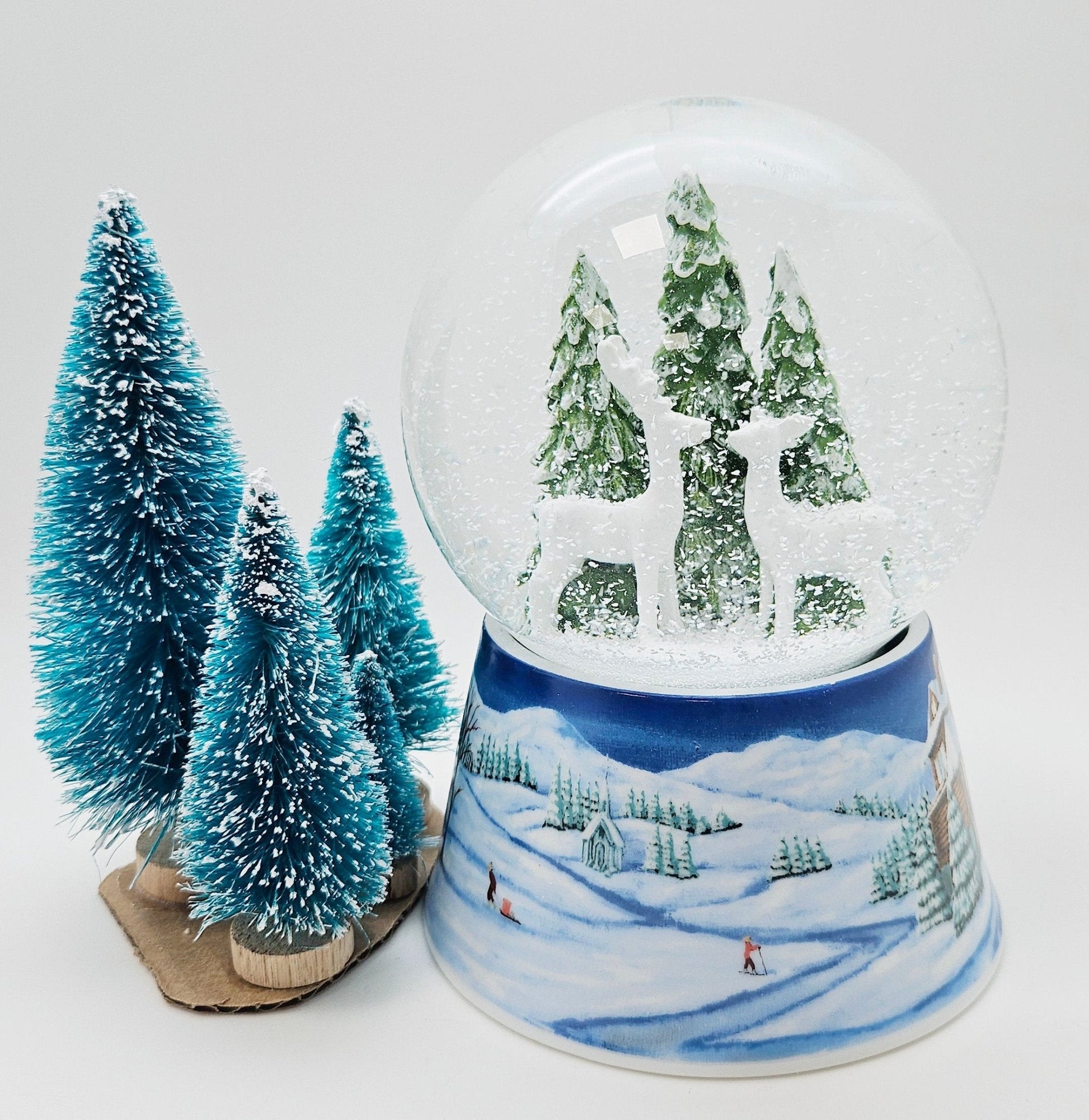 Nostalgische Schneekugel 2 Rehe auf Sockel Winterlandschaft mittelblau 100 mm Durchmesser mit Spieluhr - Schneekugelhaus
