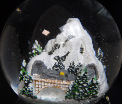 Nostalgische Schneekugel Berglandschaft mit Brücke auf Zinnsockel 100 mm Durchmesser mit Spieluhr - Schneekugelhaus