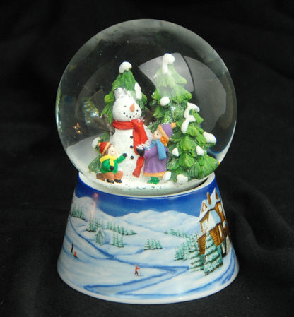 Schneekugel Schneemann zwei Kinder auf Sockel Winterlandschaft mittelblau mit Spieluhr 10 cm Durchmesser - Schneekugelhaus